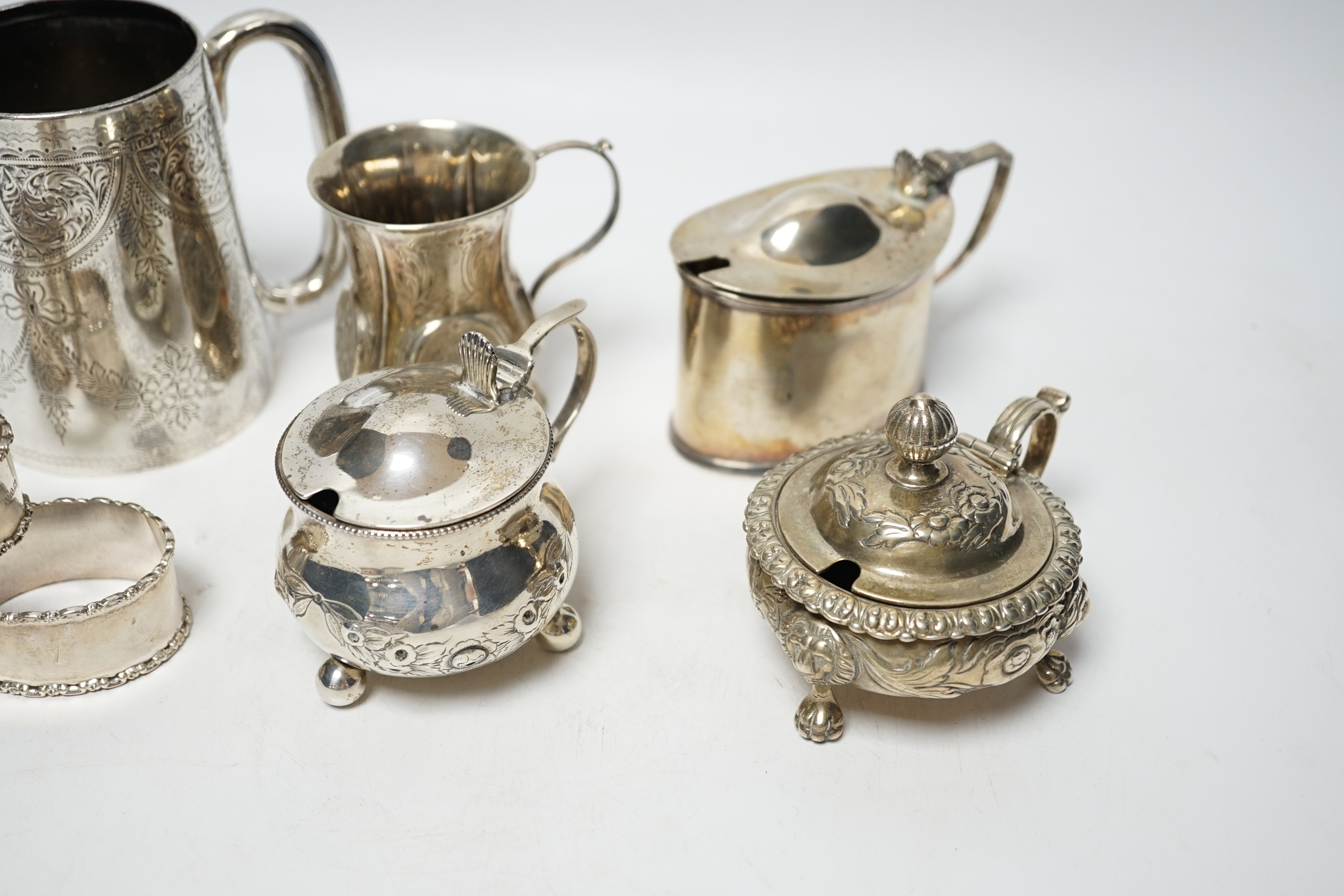 A late Victorian engraved silver mug, Hilliard & Thomason, Birmingham, 1900, 10.2cm, three assorted silver mustard pots including Victorian, a small Victorian silver christening mug and a set of six silver napkin rings,